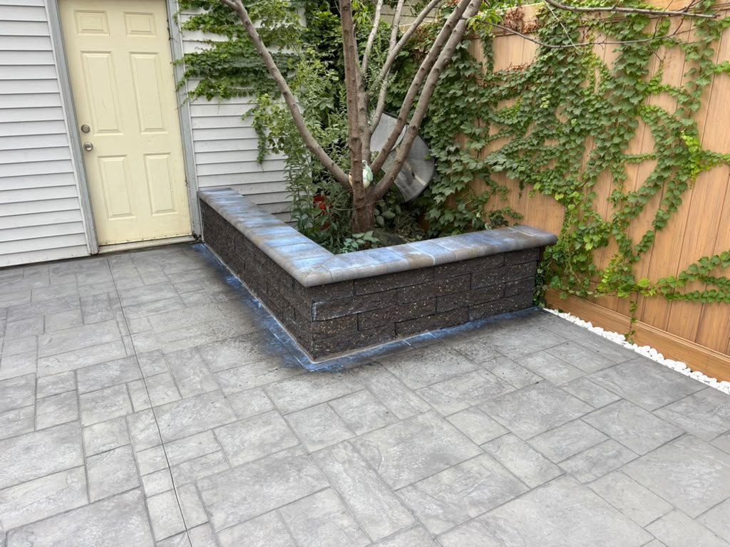 Block seating wall with built-in planter next to a stamped patio — Chicago, IL