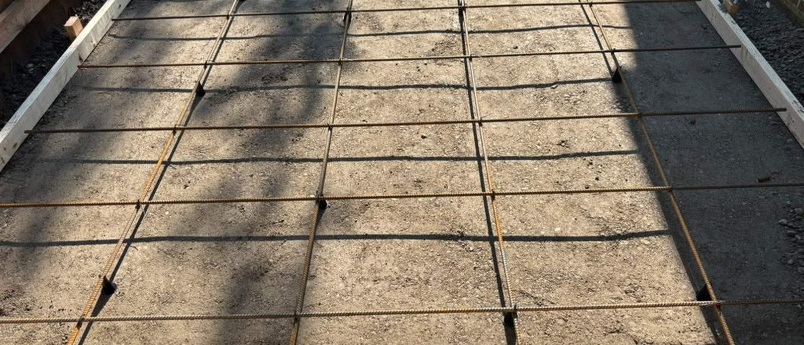Wire mesh and wood forms set over the compacted base before the pour — Chicago, IL