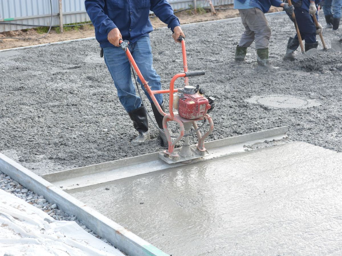 Crew finishing fresh concrete on a job site